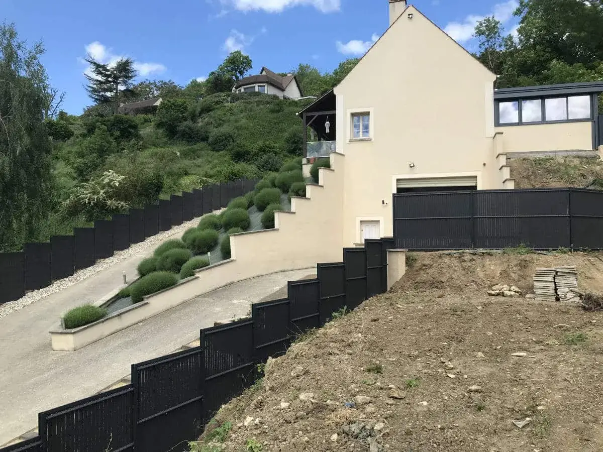 Mur de soutènement enduit en escalier retenant un talus planté de topiaires — Le Carré Vert (37)