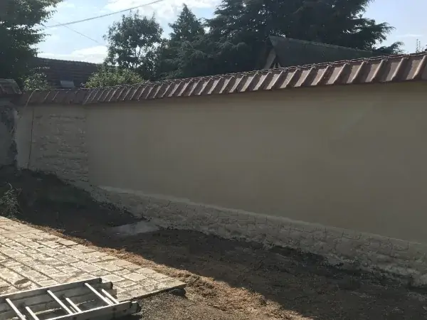Mur de clôture ravalé : enduit crème et chaperon en tuiles — Le Carré Vert, Indre-et-Loire (37)