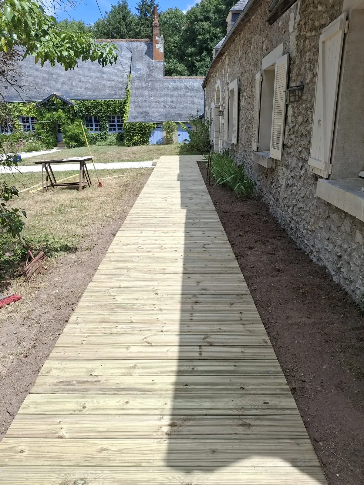 Cheminement en bois posé le long d'une longère — Le Carré Vert, Indre-et-Loire